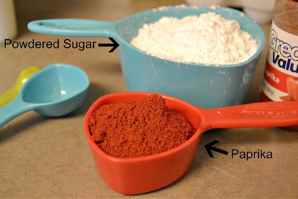 Paprika and powdered sugar in measuring cups.