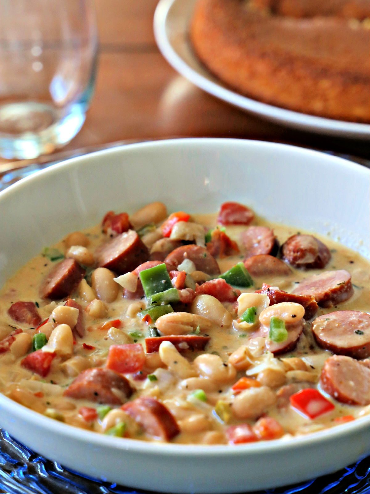 White soup bowl with cajun chili and cornbread.