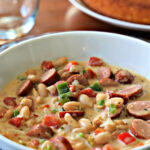 White soup bowl with cajun chili and cornbread.