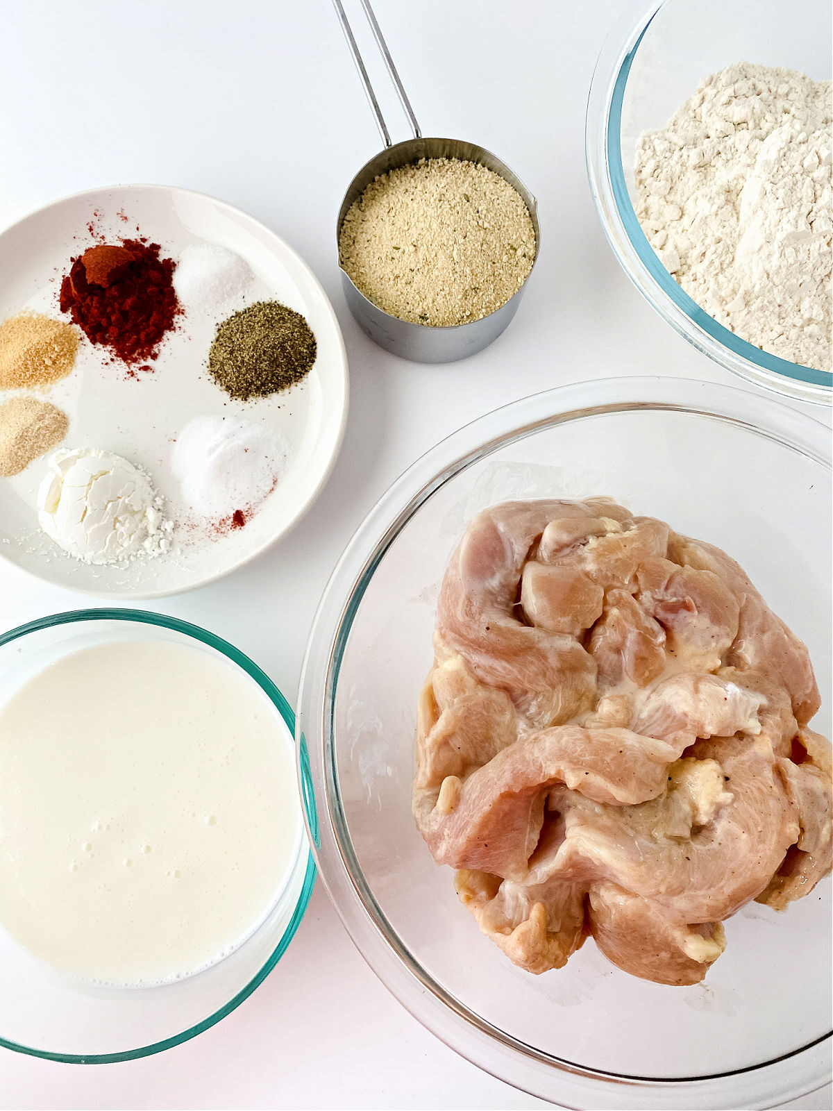 Sliced chicken breasts, seasoning, buttermilk, and breadcrumbs.