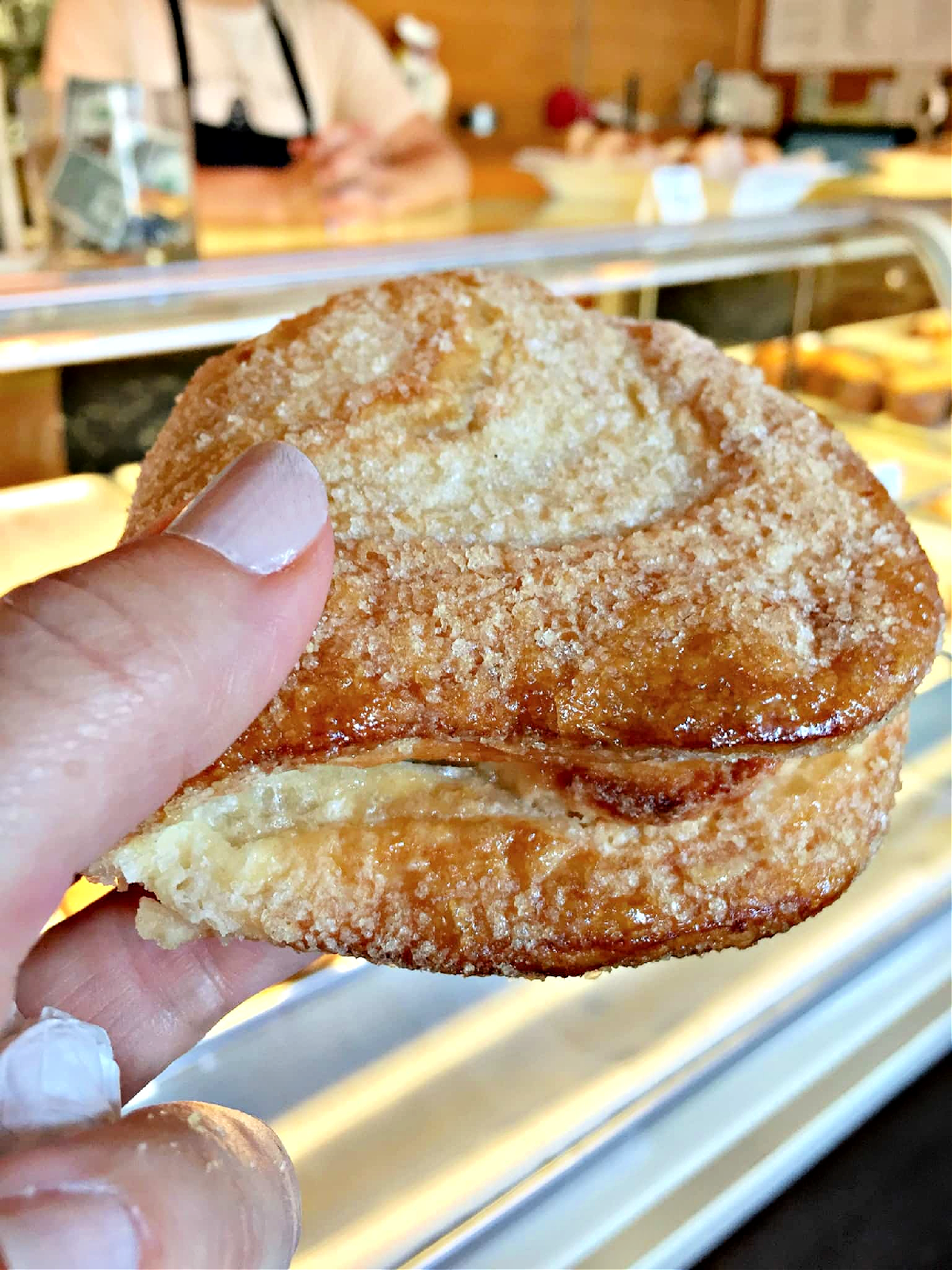 Where To Eat in Pittsburgh A woman's fingers holding a fresh mele at a bakery.