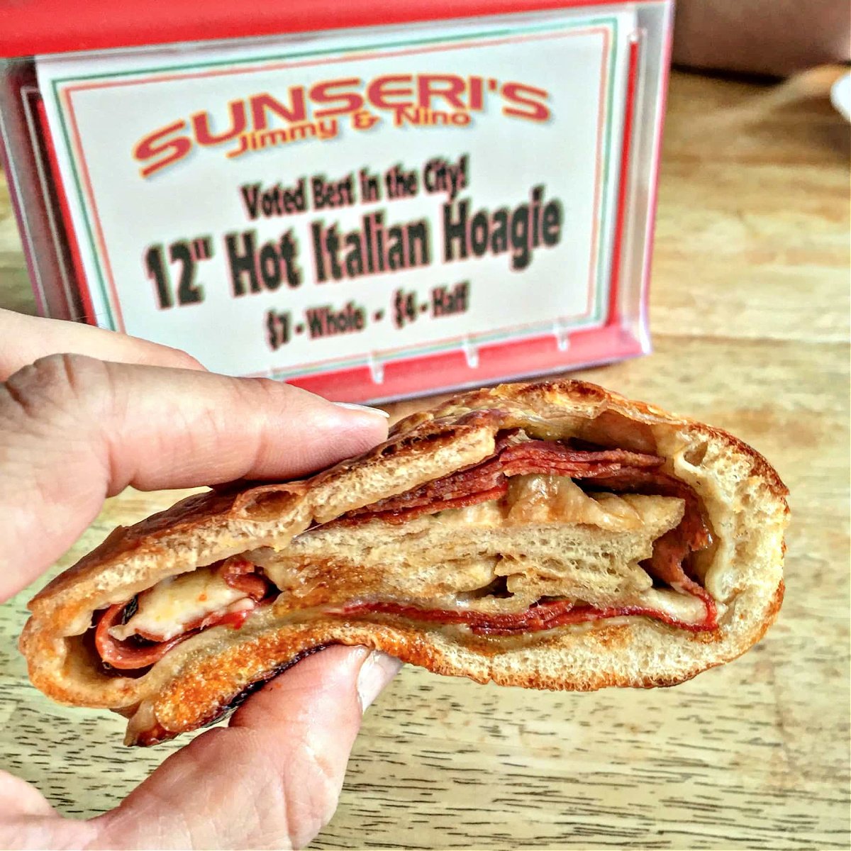 Where To Eat in Pittsburgh Woman's hand holding pepperoni Stromboli roll from Sunseri's.