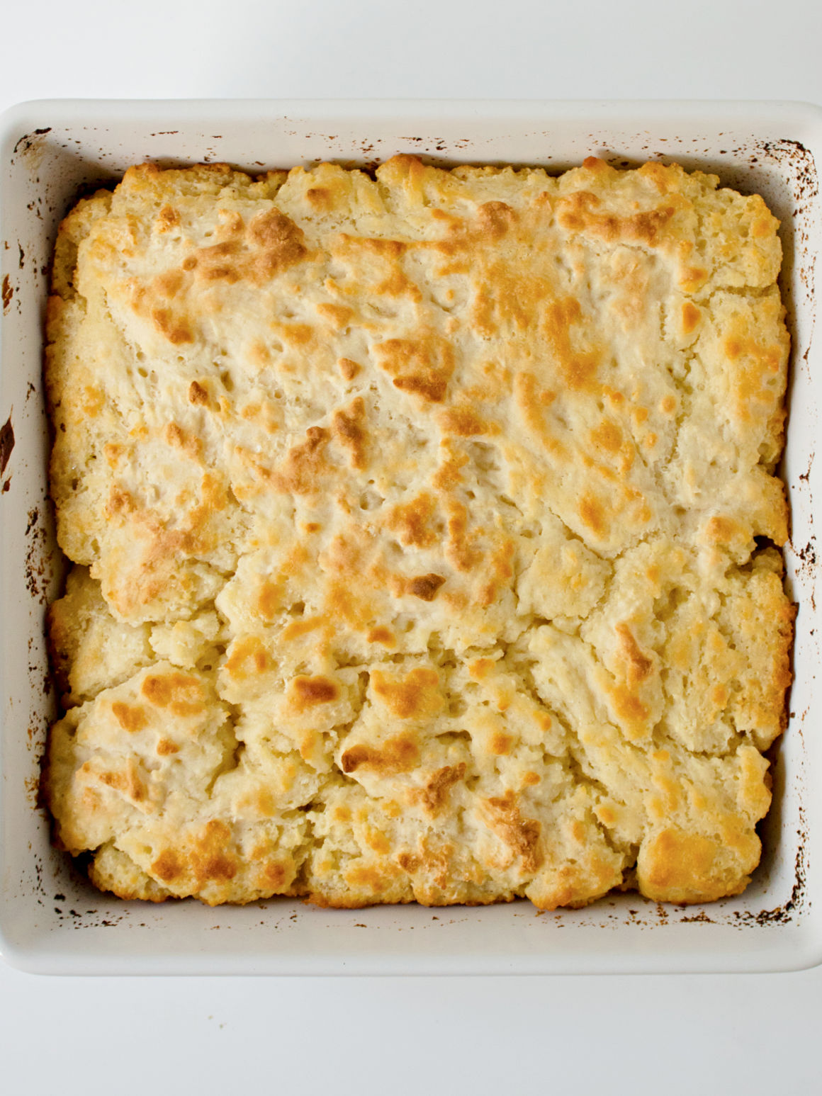 White baking pan filled with baked butter swim biscuits.