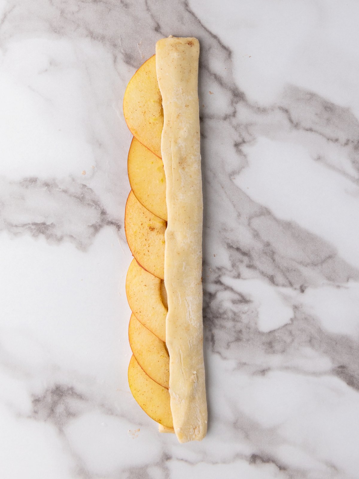 Pastry dough folded on top of sliced apples.