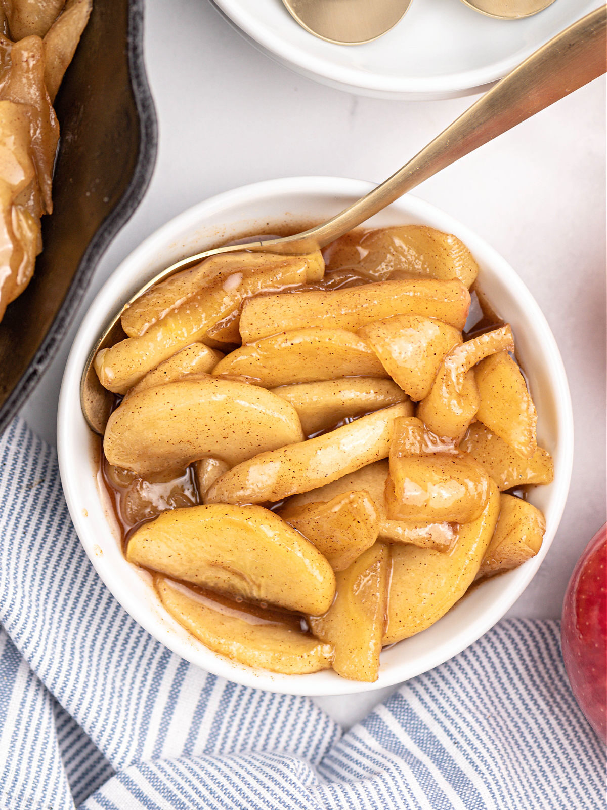 Bowl of fried apples and metal spoon.