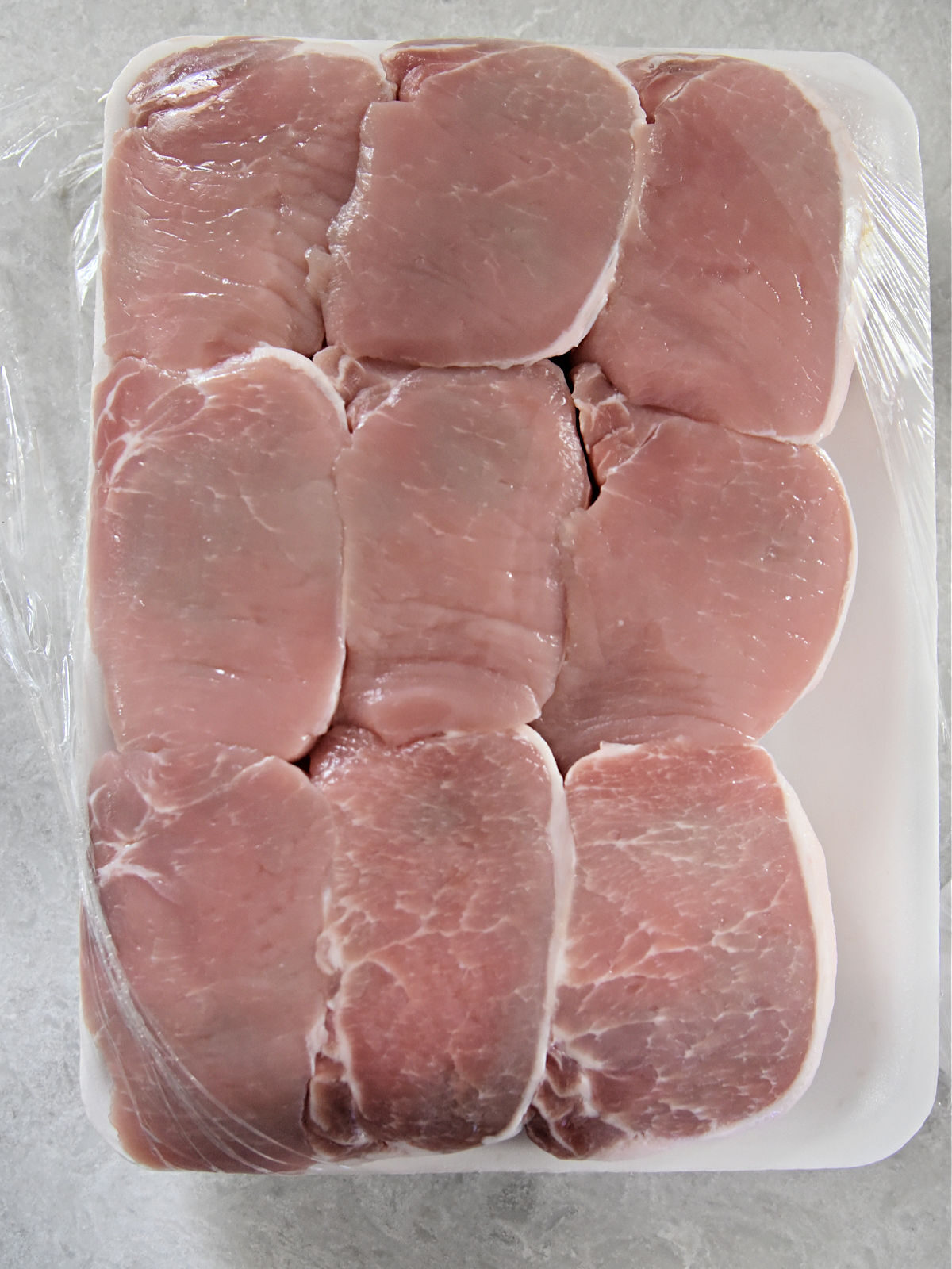 Package of nine raw thick pork chops.