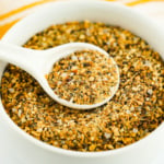 Lemon pepper seasoning in a white spoon.