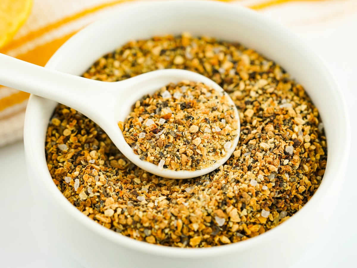 Lemon pepper seasoning in a white spoon.