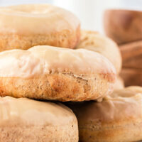 White plate stacked with glazed maple doughnuts.
