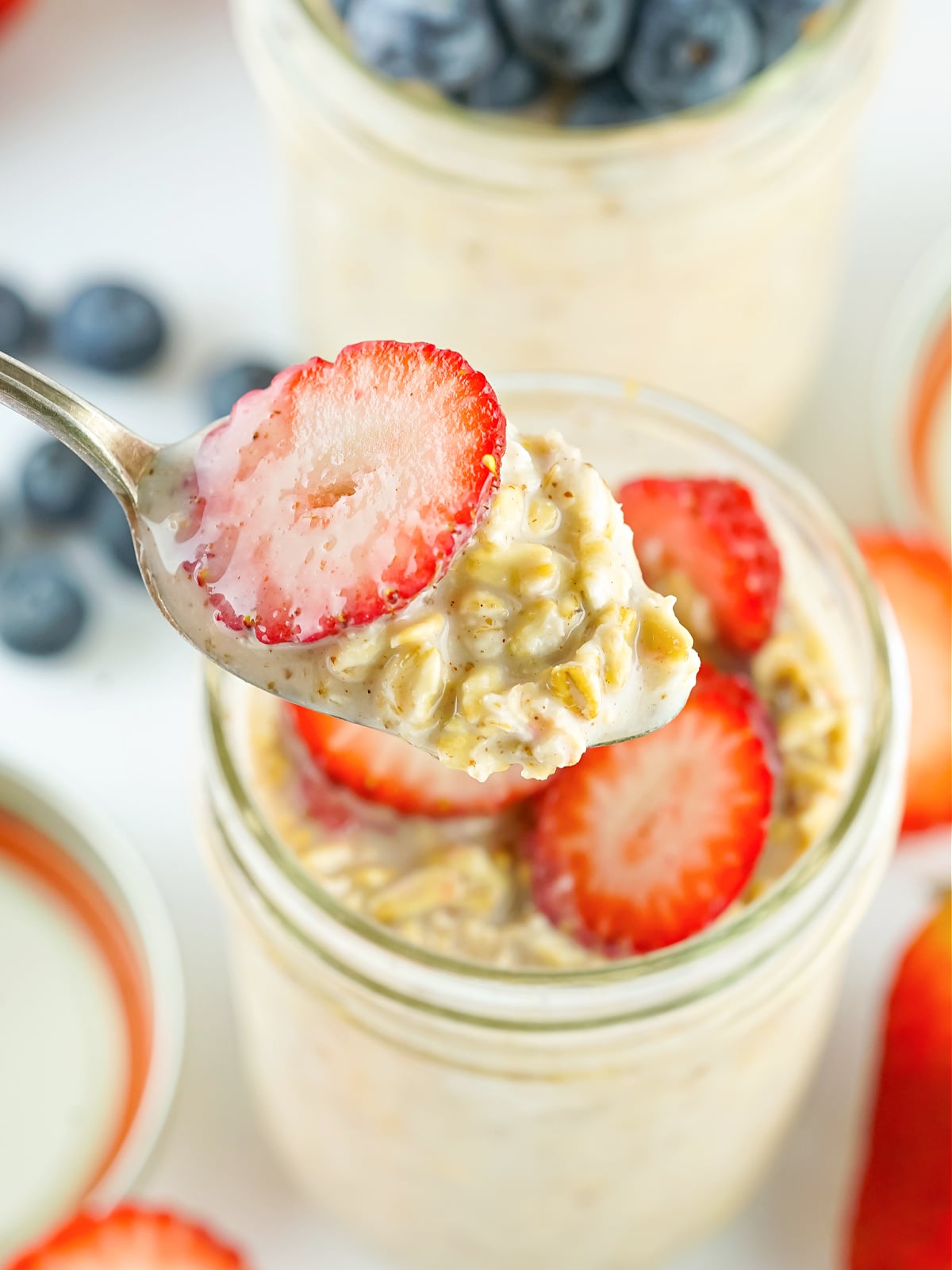 Spoonful of oats topped with strawberries.