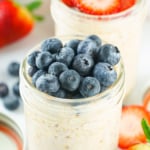 Two jars of oats topped with blueberries and strawberries.