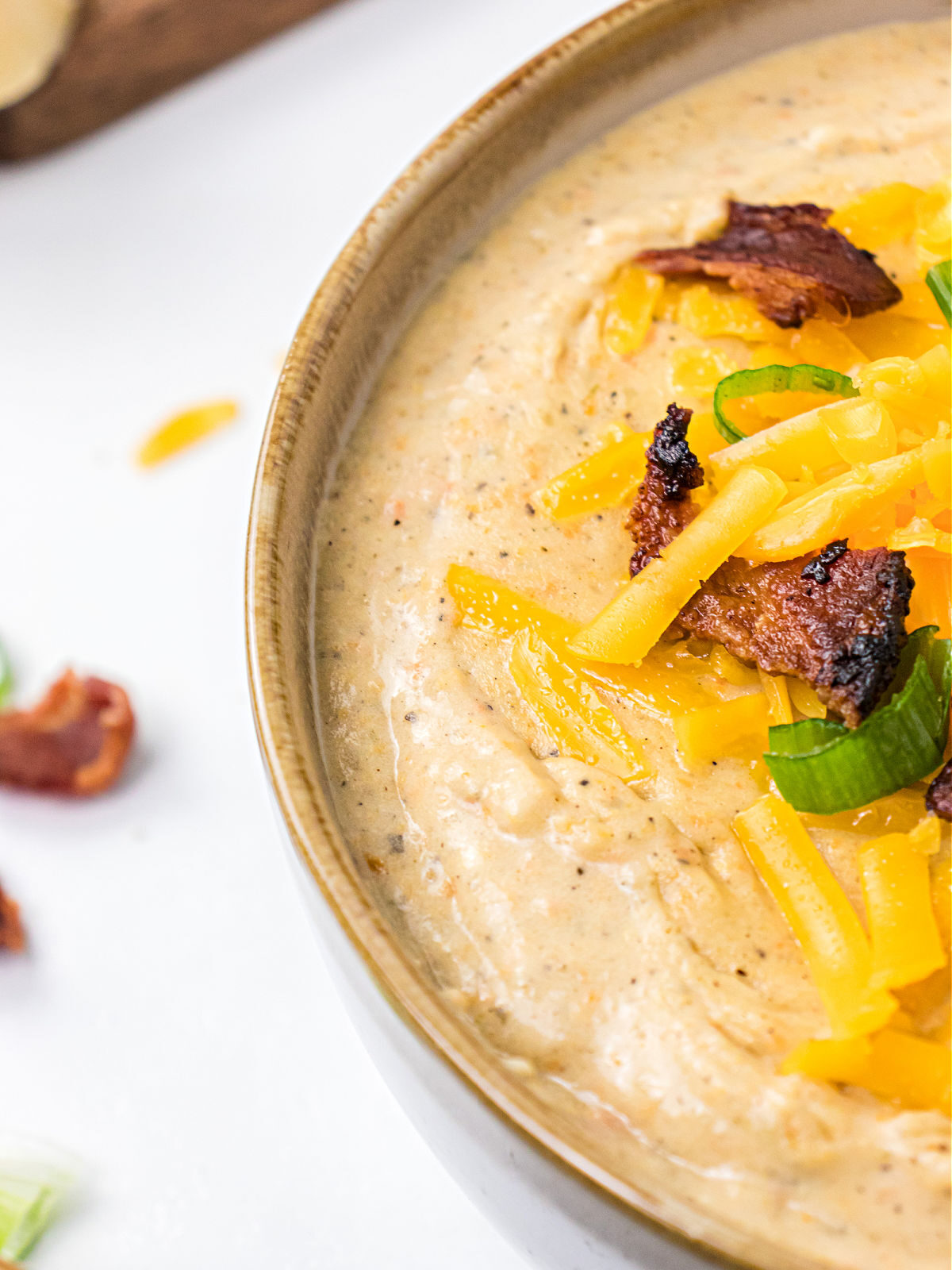 Potato soup topped with cheese, bacon, and chopped chives.