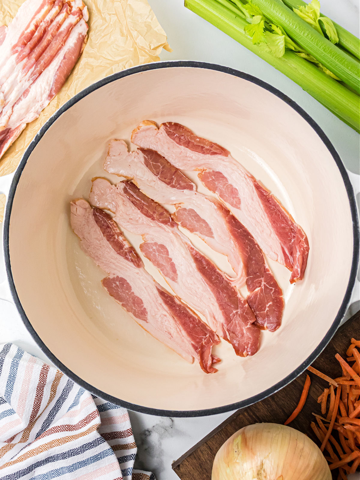 Four bacon slices cooking in a large pot.