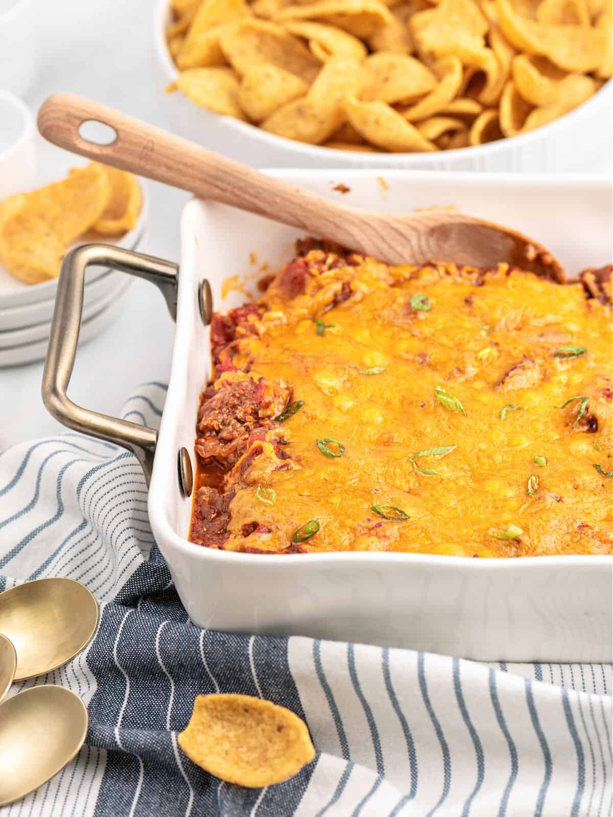Be sure to have plenty of corn chips to scoop up its cheesy, meaty deliciousness. White casserole dish filled with sloppy Joe dip and corn chips on the side.