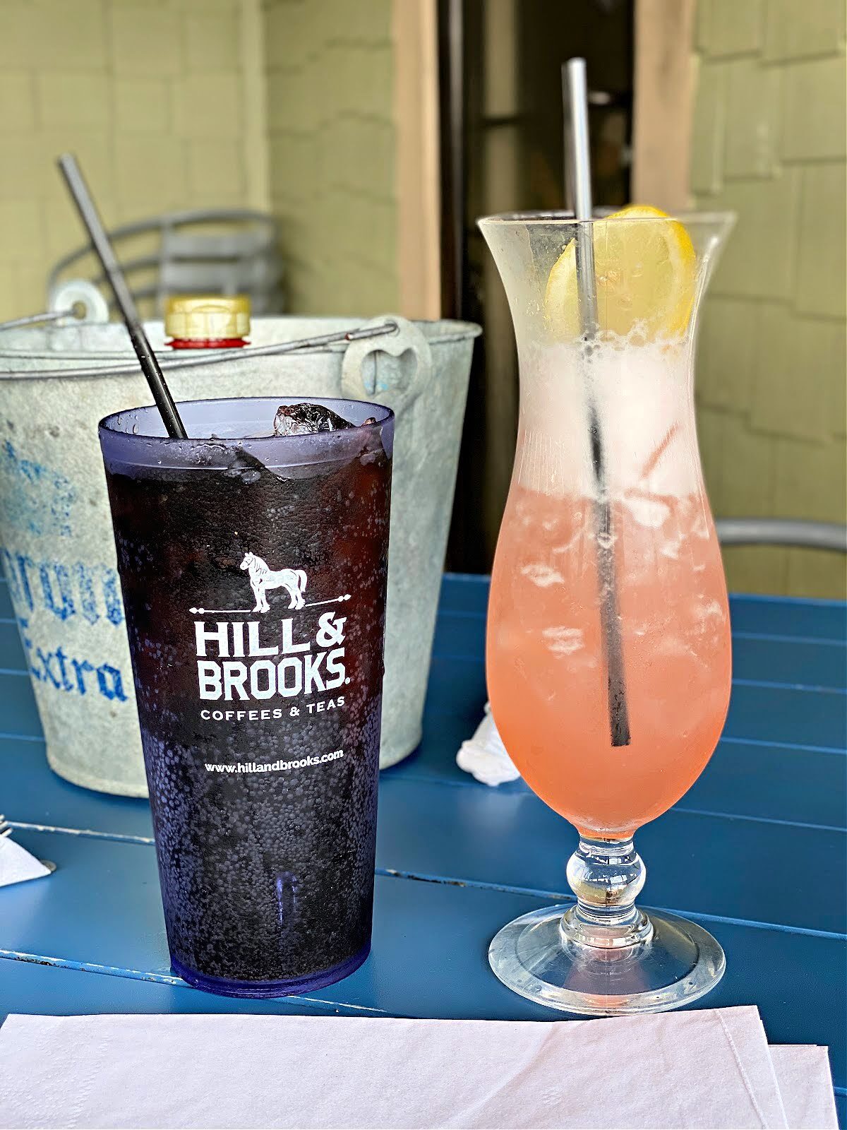 Tall glass filled with spiked strawberry lemonade and a glass of diet Coke.