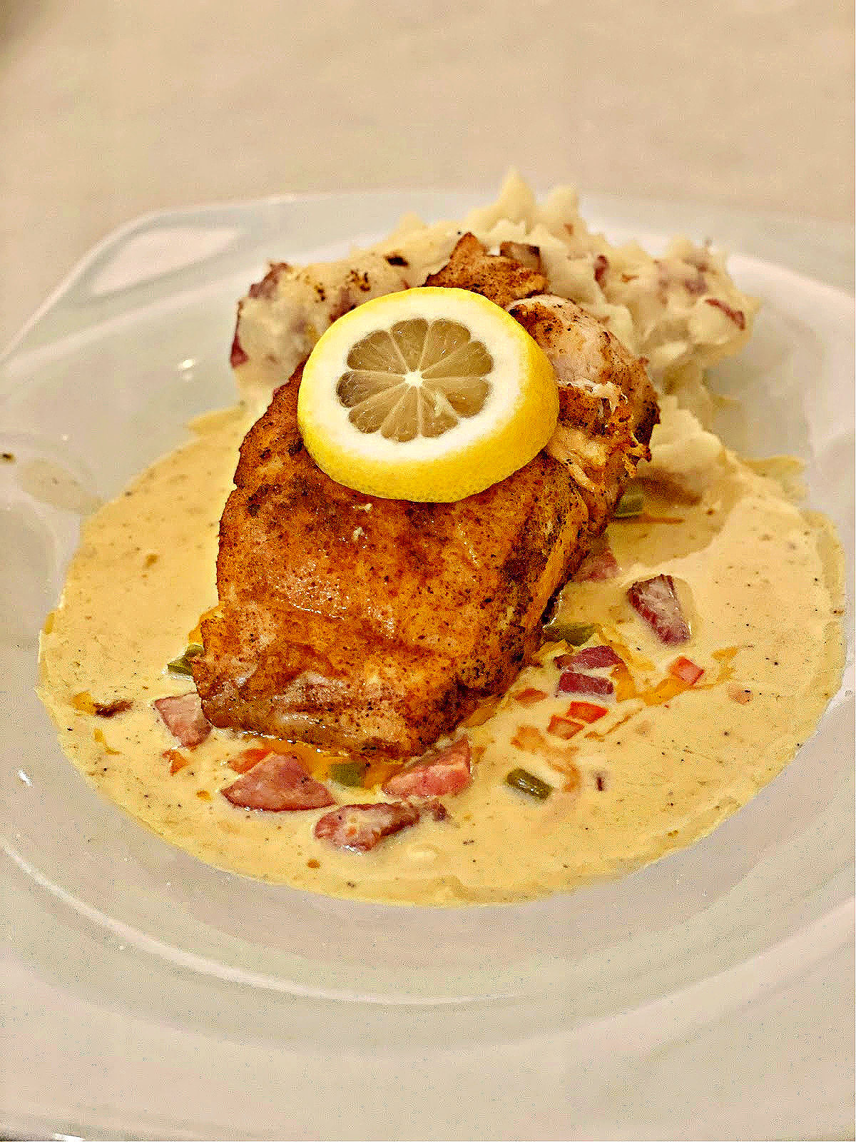 Tripletail fish dinner with cream sauce, lemon slice, and mashed potatoes.