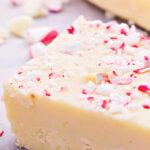 Slice of white chocolate fudge topped with peppermint pieces.