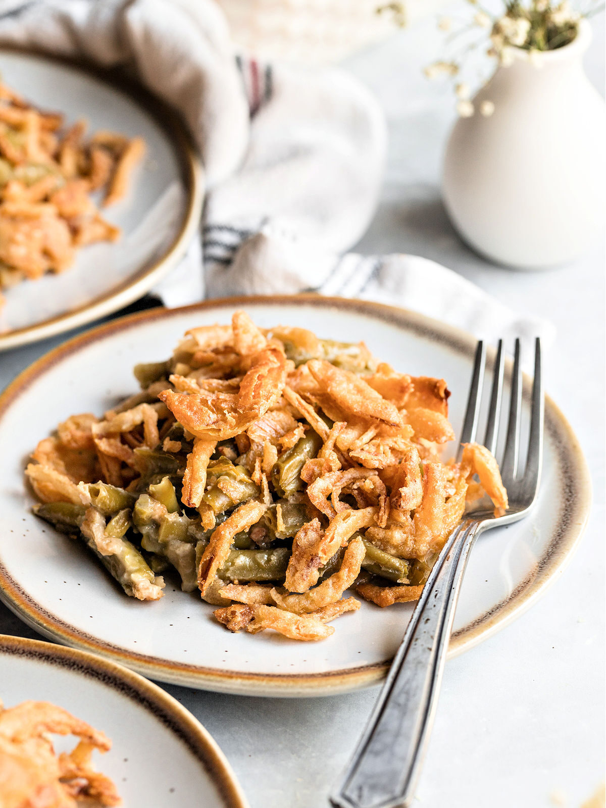 Fork and plate with green beans and French fried onions.