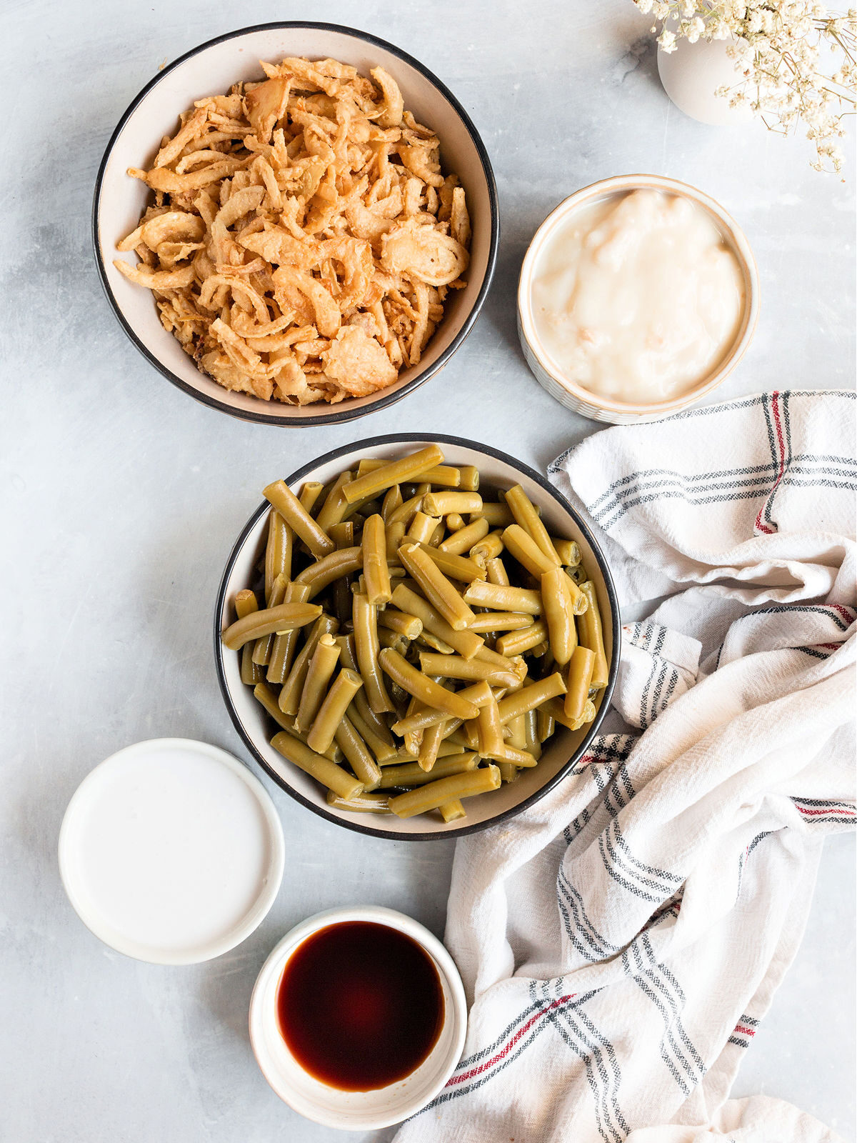 French fried onions, cream soup, green beans, and soy sauce on a counter.