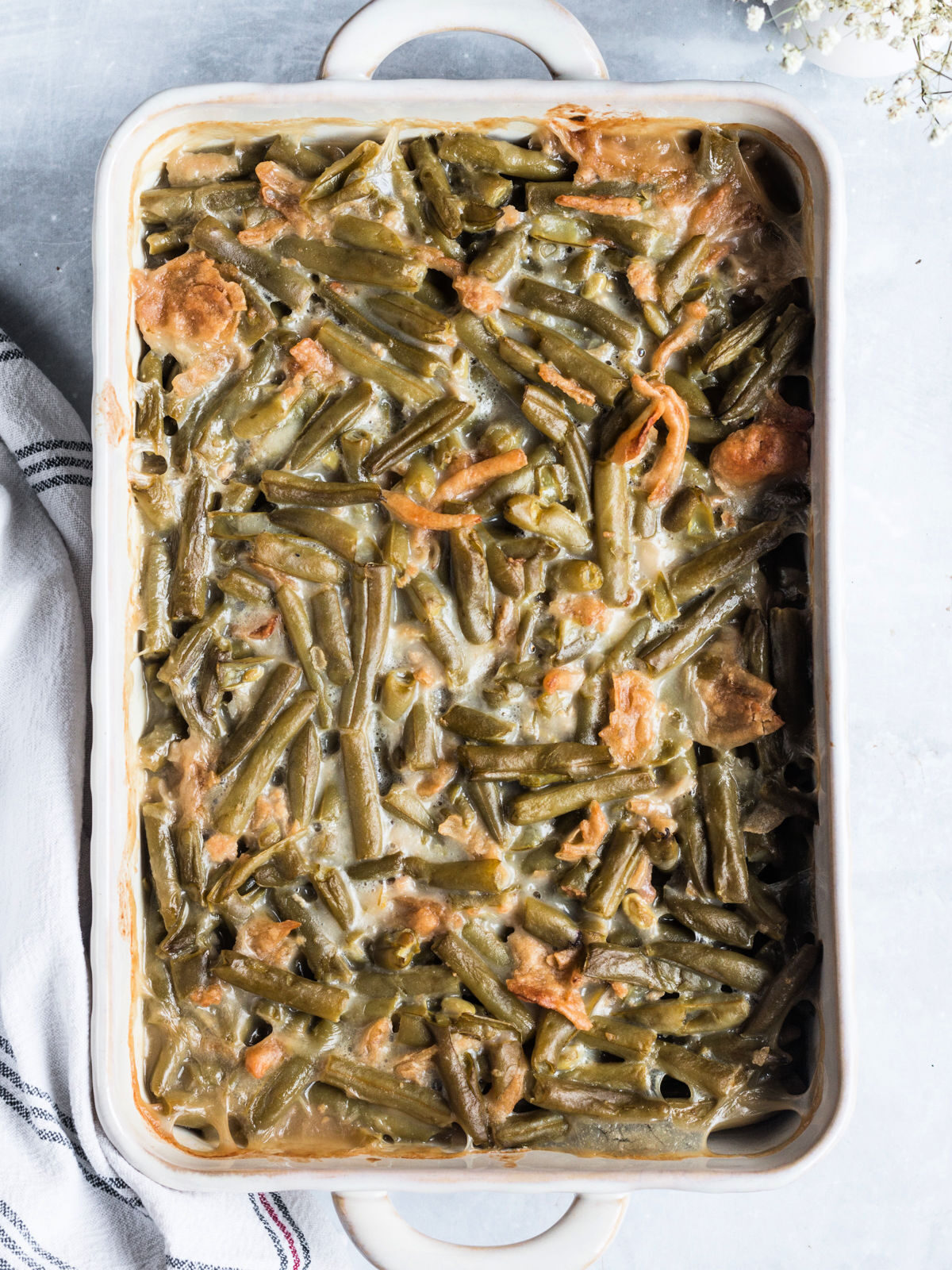 Green beans mixed with soup and onions in a baking dish.