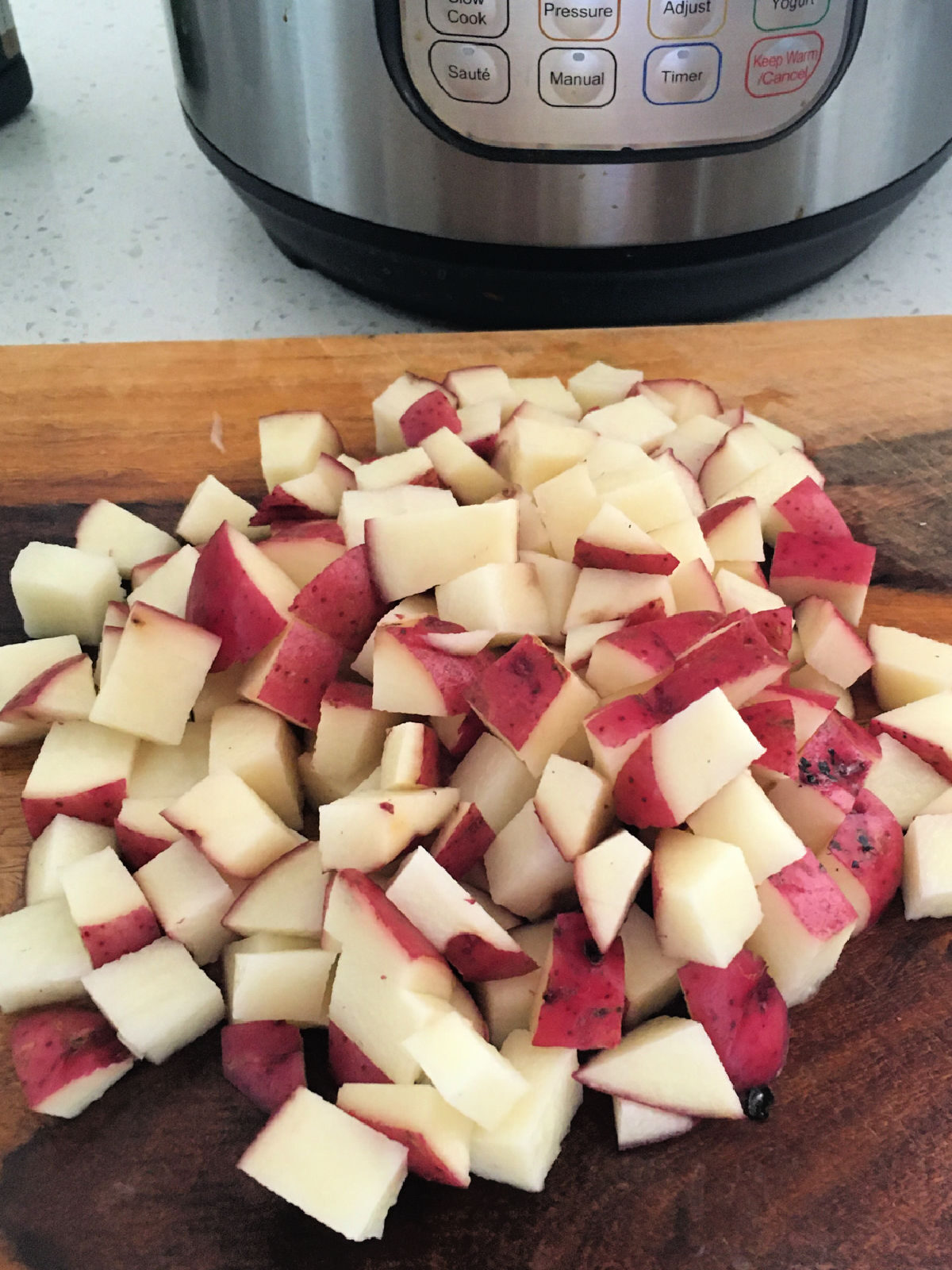 Diced red potatoes on a cutting board.