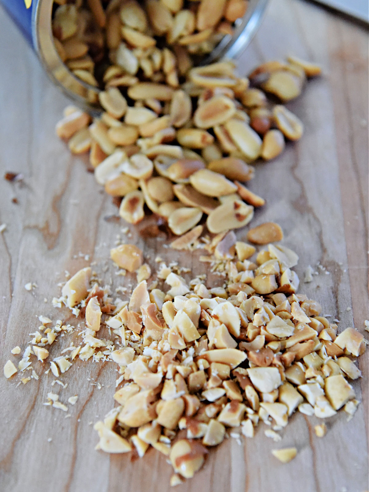 Chopped peanuts on a wooden cutting board.