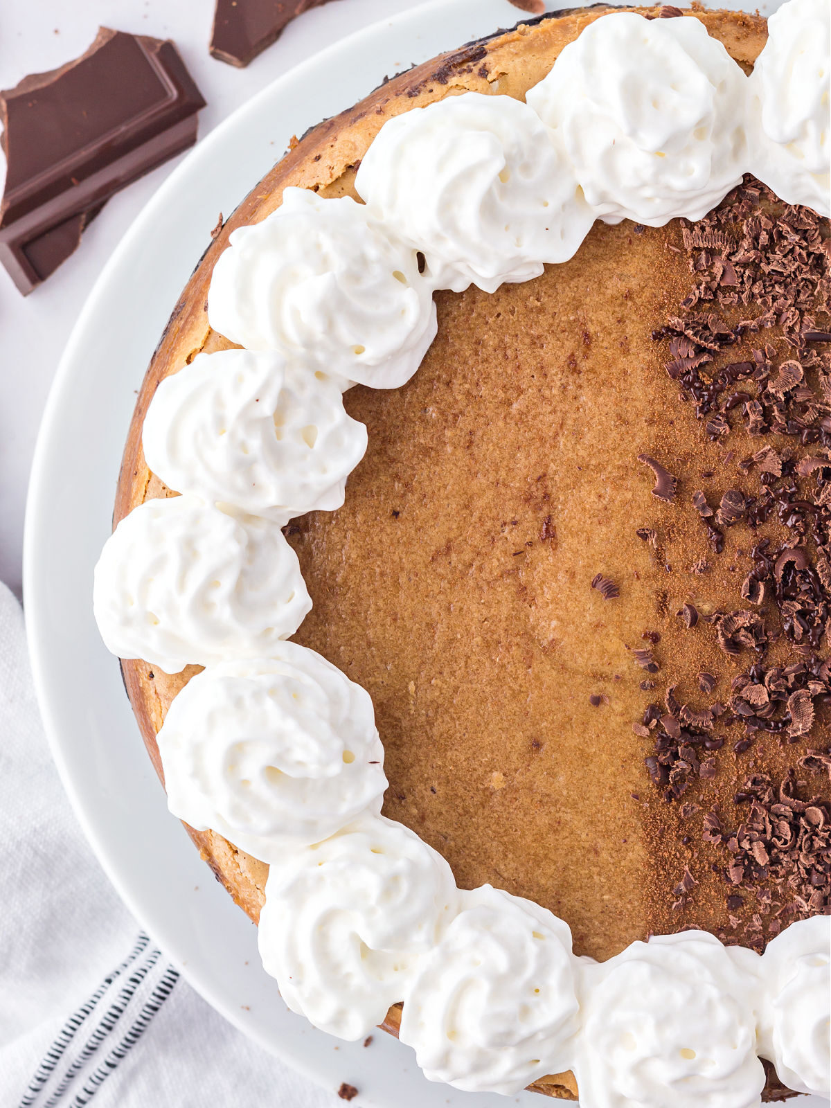 Tiramisu cheesecake topped with chocolate shavings and whipped cream.