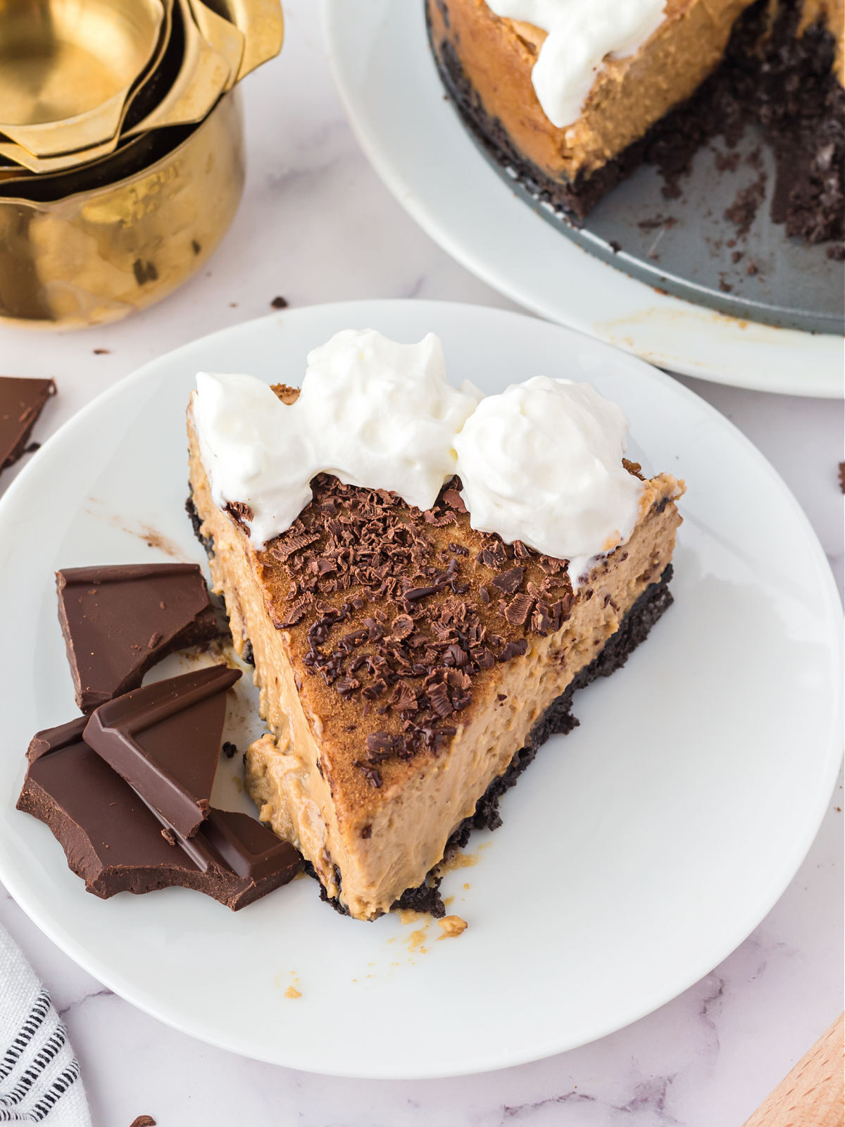 Slice of tiramisu cheesecake on a white plate.