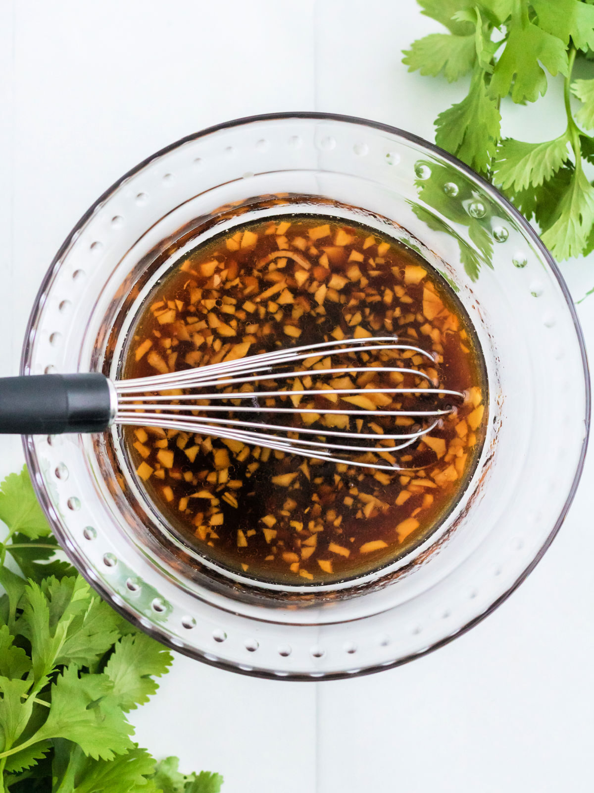 Stir fry sauce in a glass bowl with a whisk.
