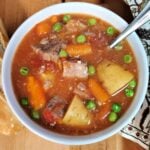 Bowl of hearty beef stew and slice of bread.