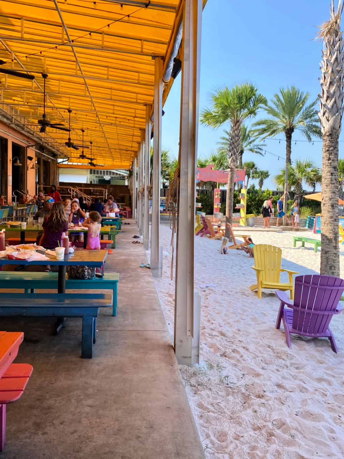 Restaurant patio with sandy beach.