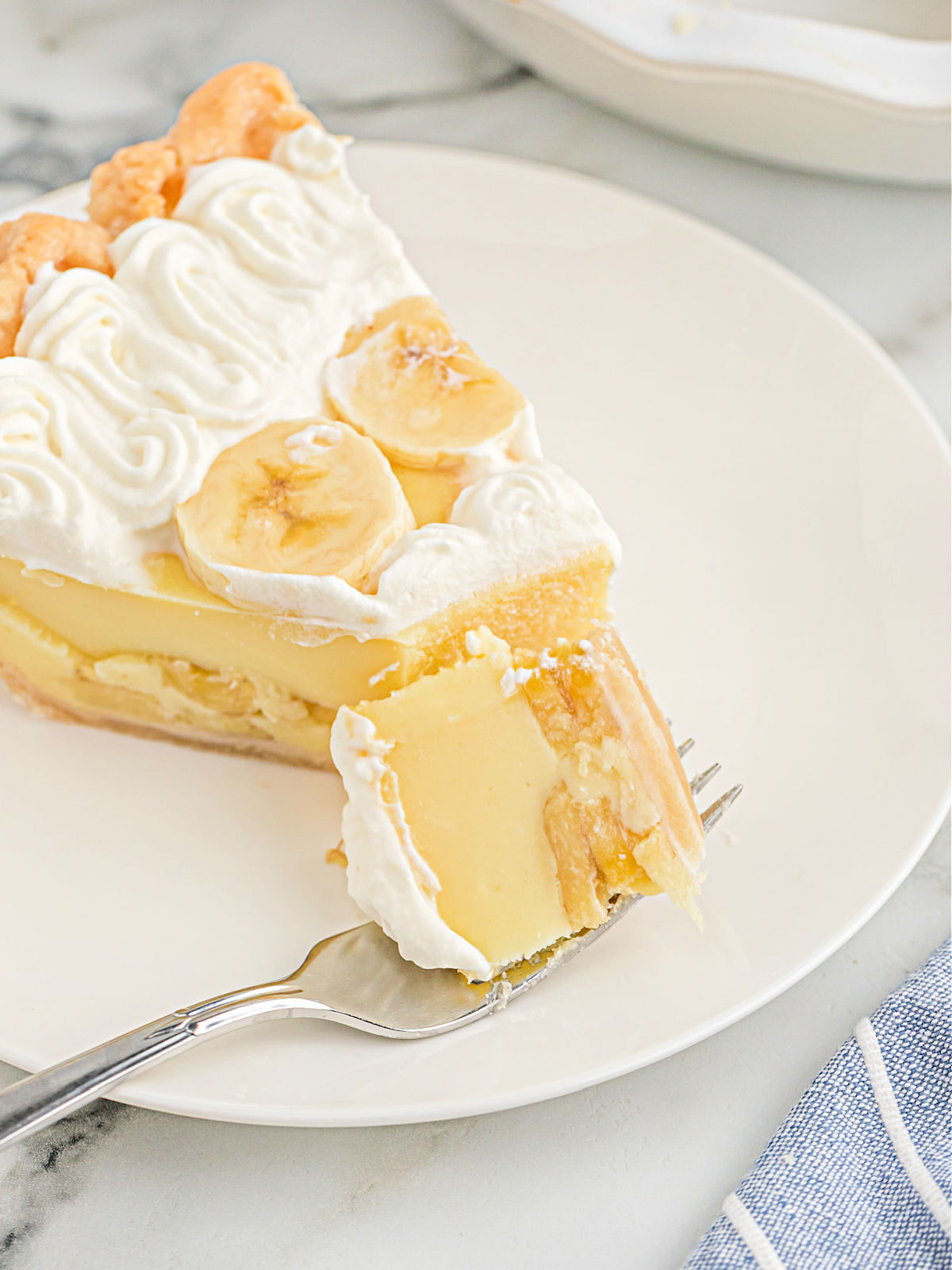 Bite of banana cream pie on a fork.
