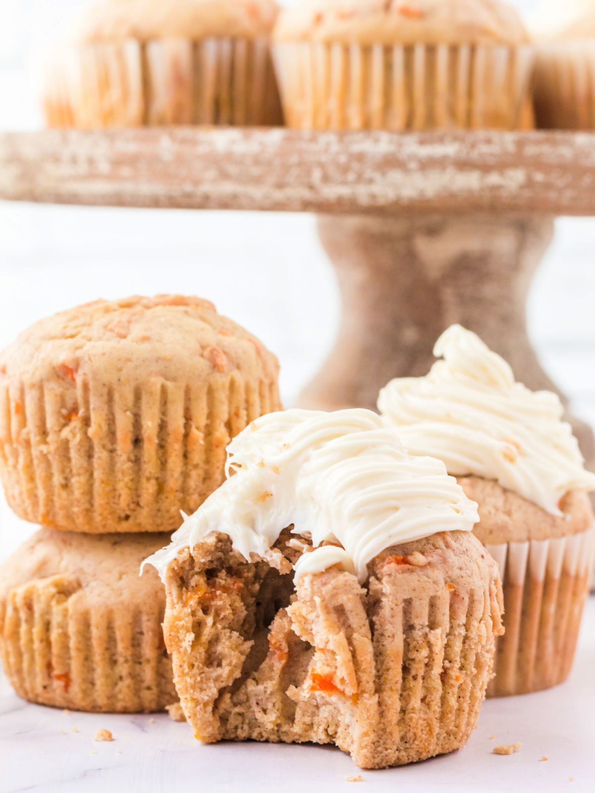 Carrot cupcake with a bite eaten out of it.