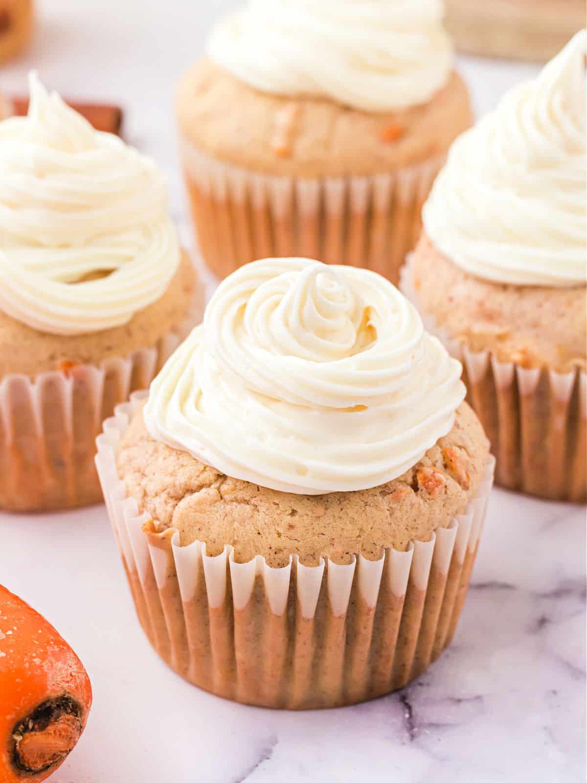 Carrot cupcakes topped with cream cheese frosting.