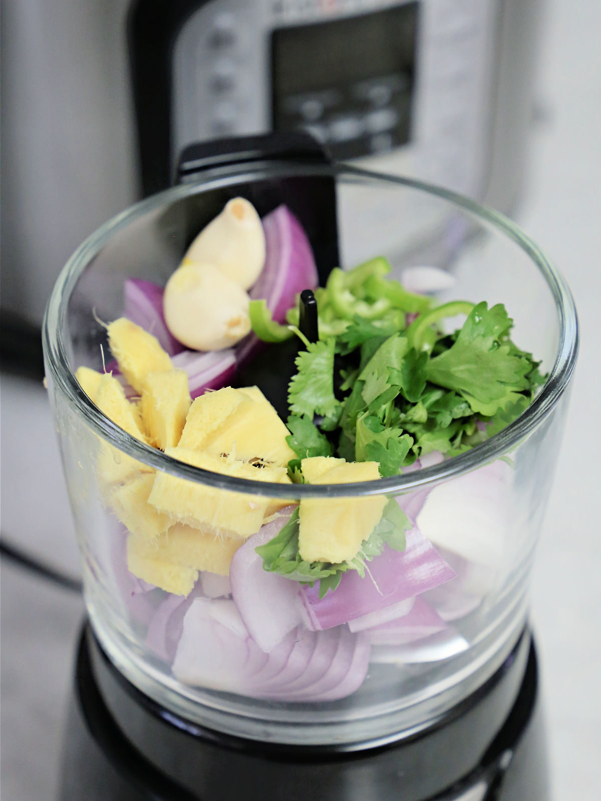 Onions, ginger, garlic, and cilantro in a food processor.