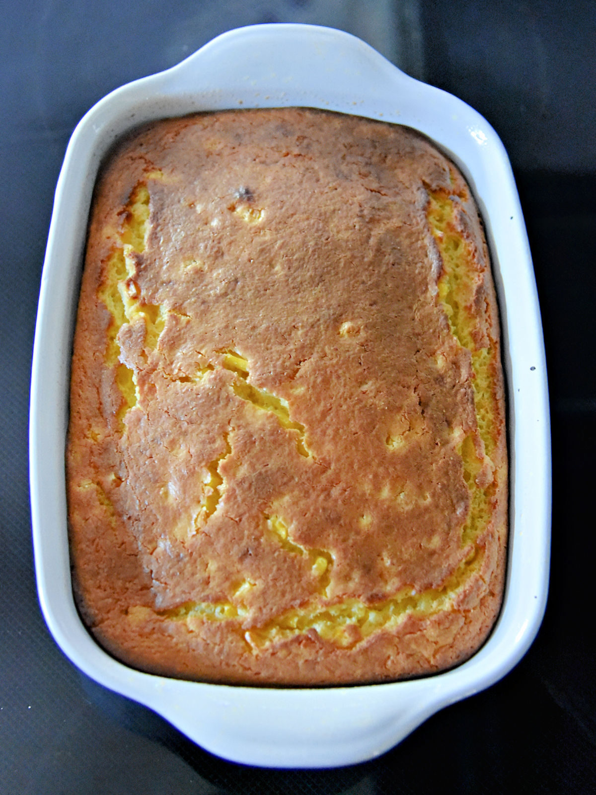 Corn pudding in a white baking dish.
