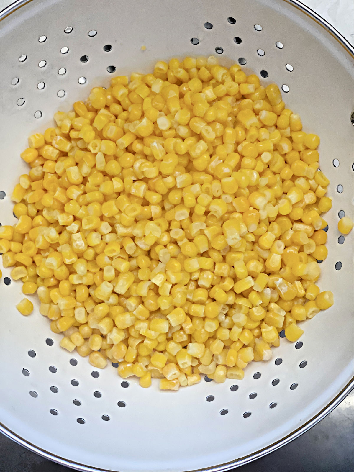 Corn draining in a collander.