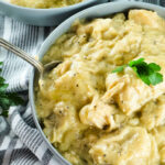 Bowl of chicken and dumplings with a spoon.