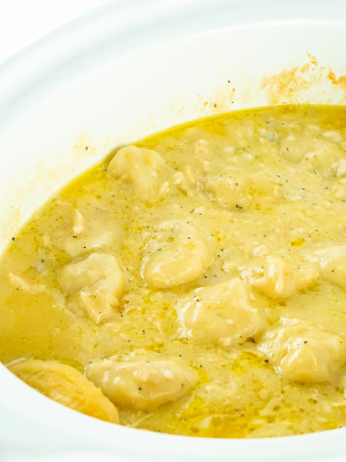 Chicken and dumplings cooking in a CrockPot.