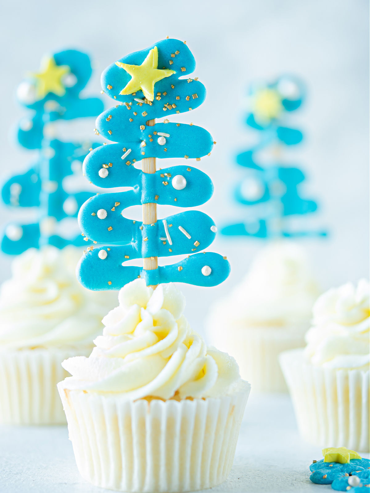 Christmas cupcakes with blue Christmas trees.