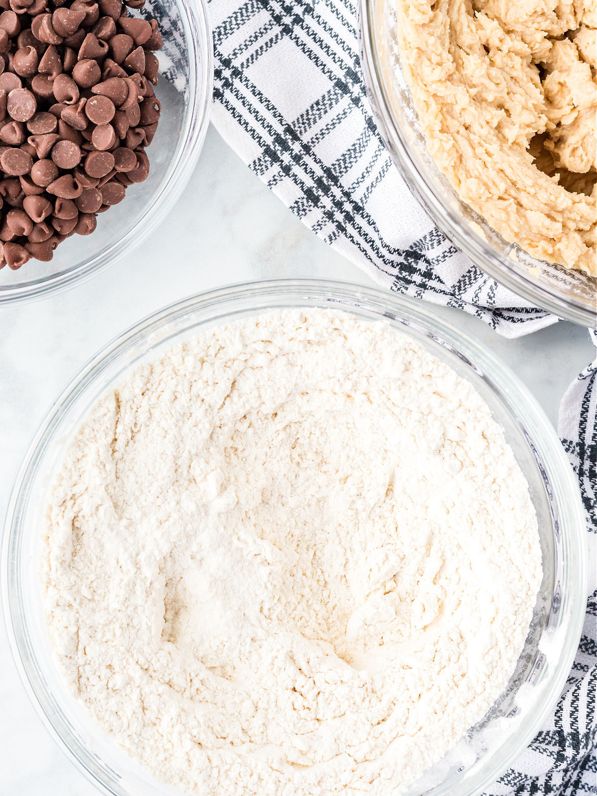 Bowls of chocolate chips, flour, and creamed sugar and butter.