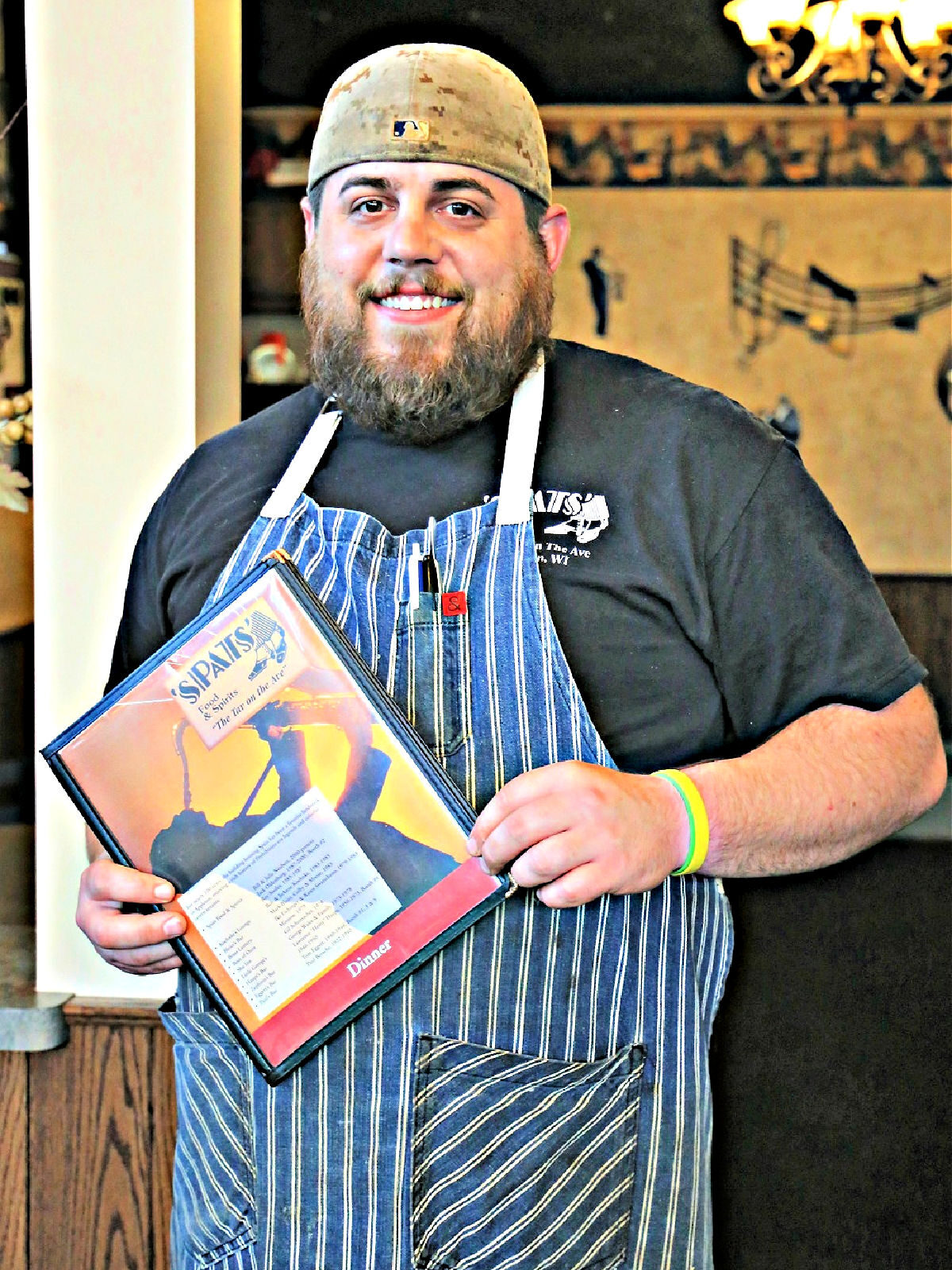 Chef wearing an apron and holding a menu.