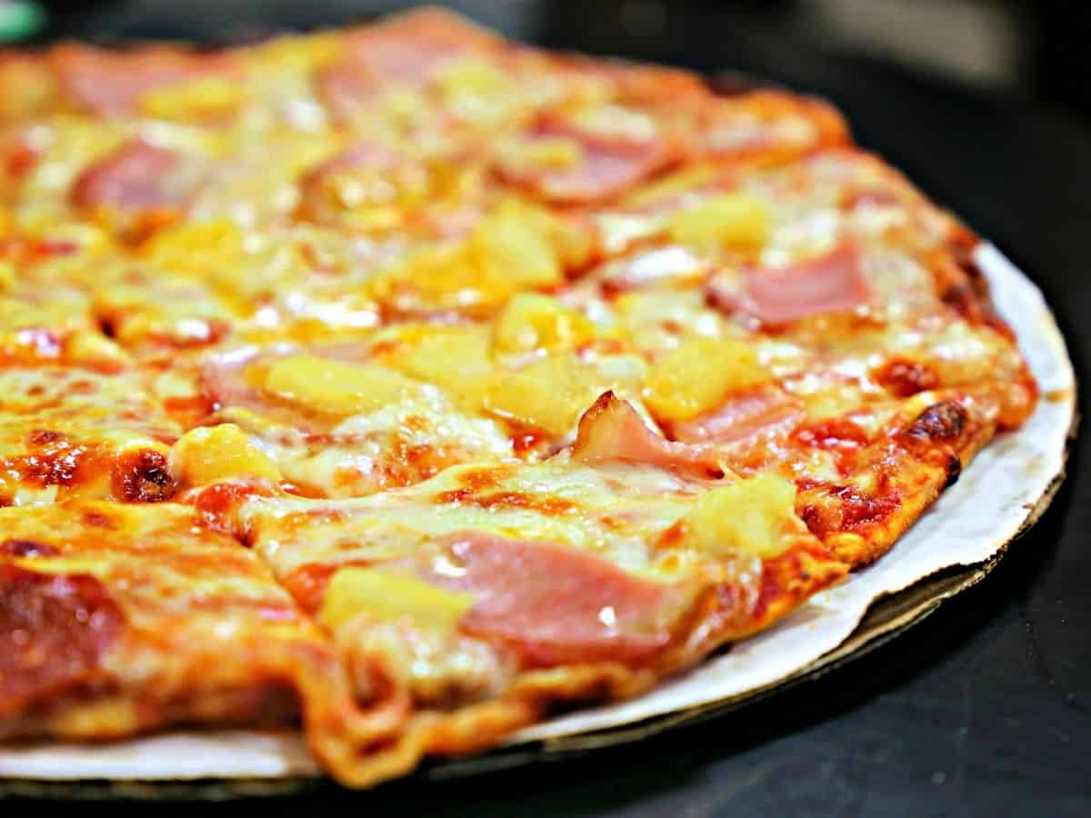 Take-and-Bake Pizza at Simon's Specialty Cheese Close up look at a Hawaiian pizza with ham and pineapple.