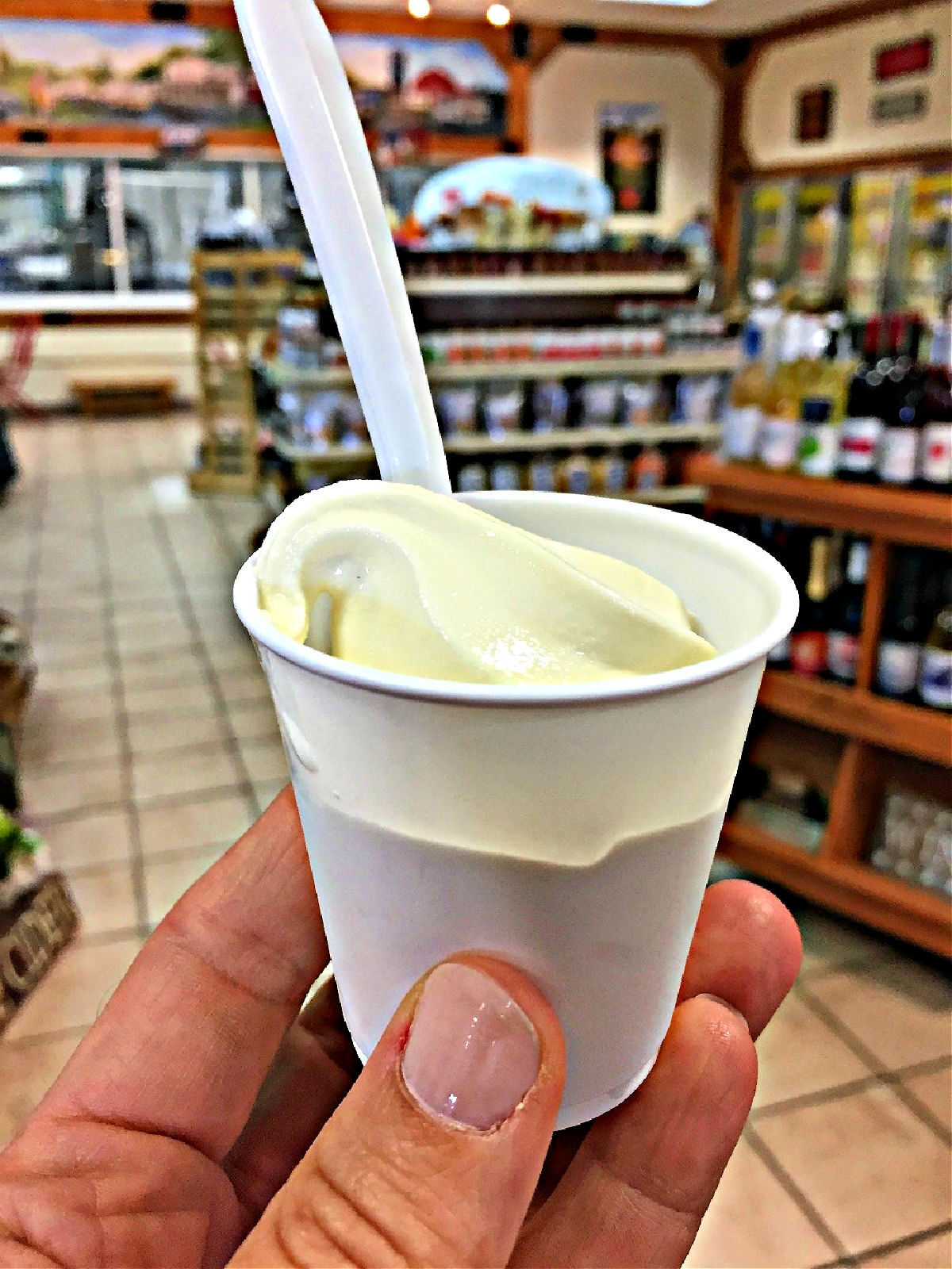 Ice Cream at Lamers Dairy Woman's hand holding small cup of vanilla ice cream.