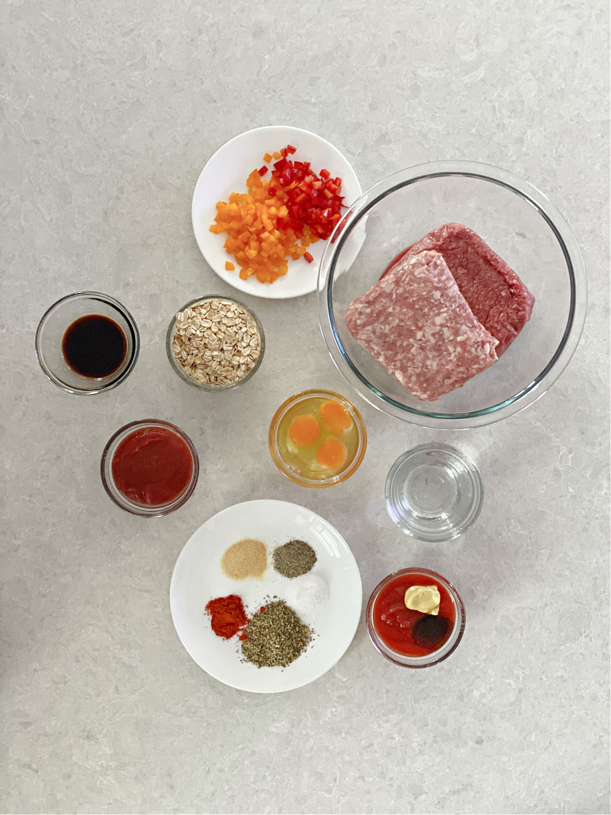 Ground beef, ground pork, chopped bell peppers, seasoning, and eggs.