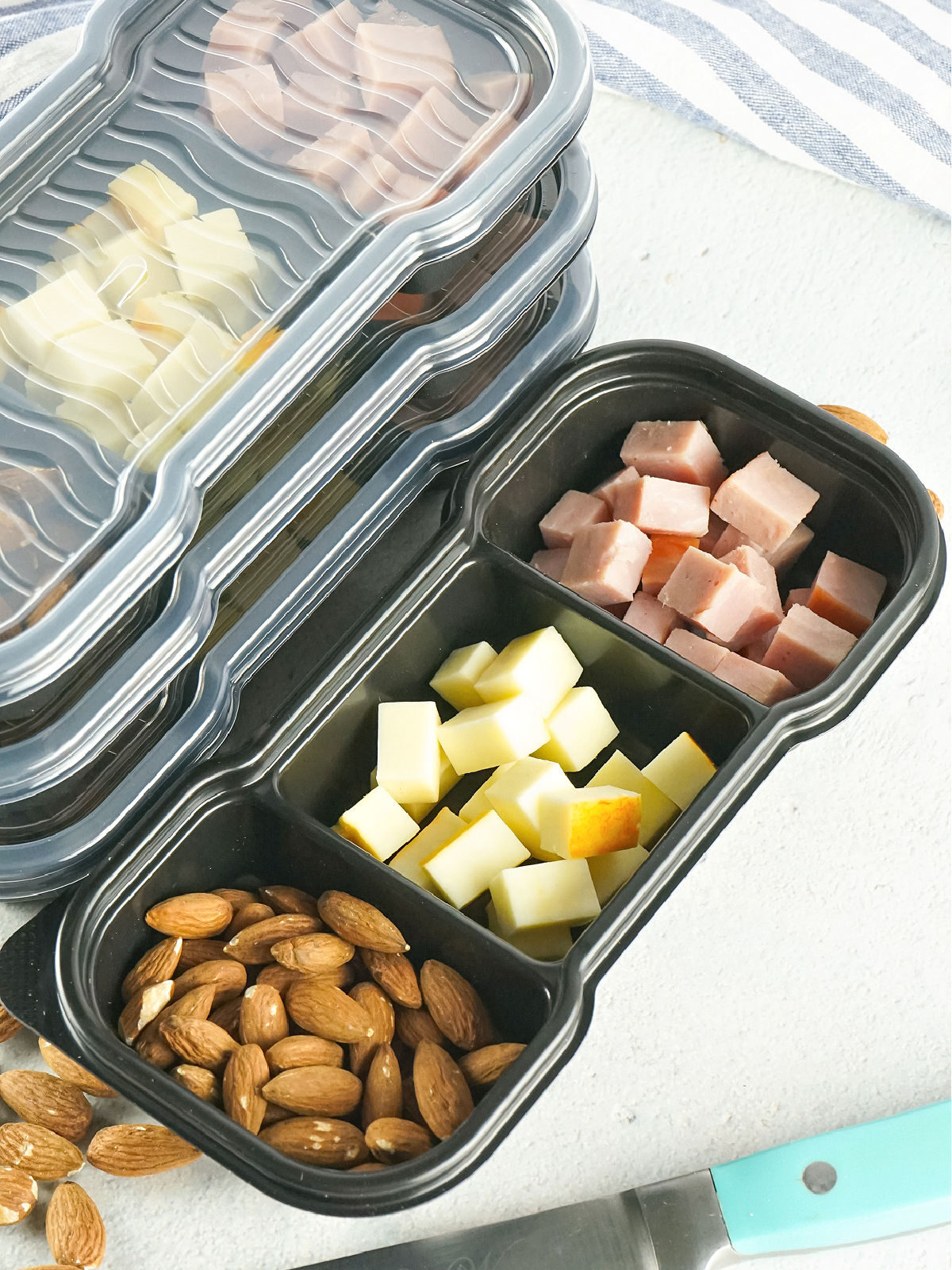 Almonds, cheese, and meat in a meal prep container.