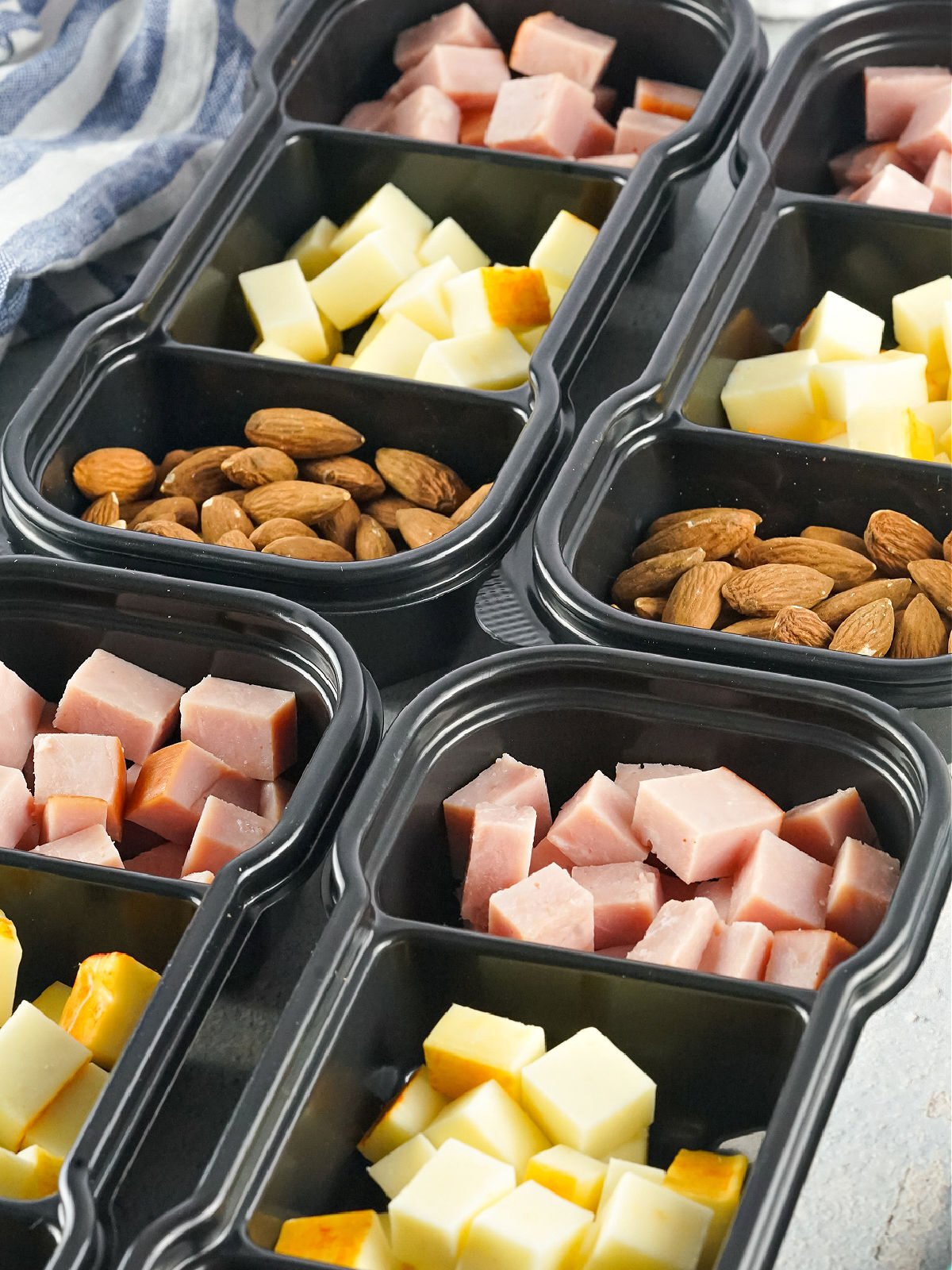 Meal prep protein packs filled with meat, cheese, and nuts.