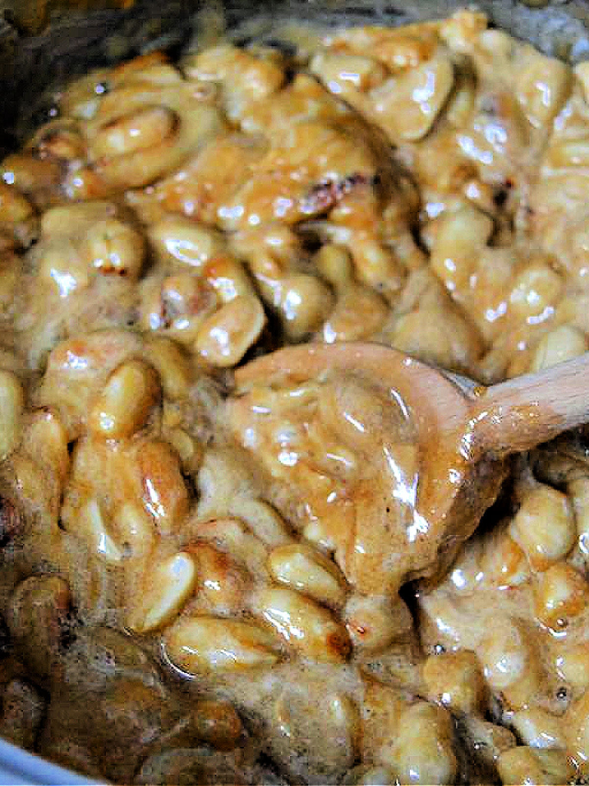 Stirring peanut brittle in a metal pot.