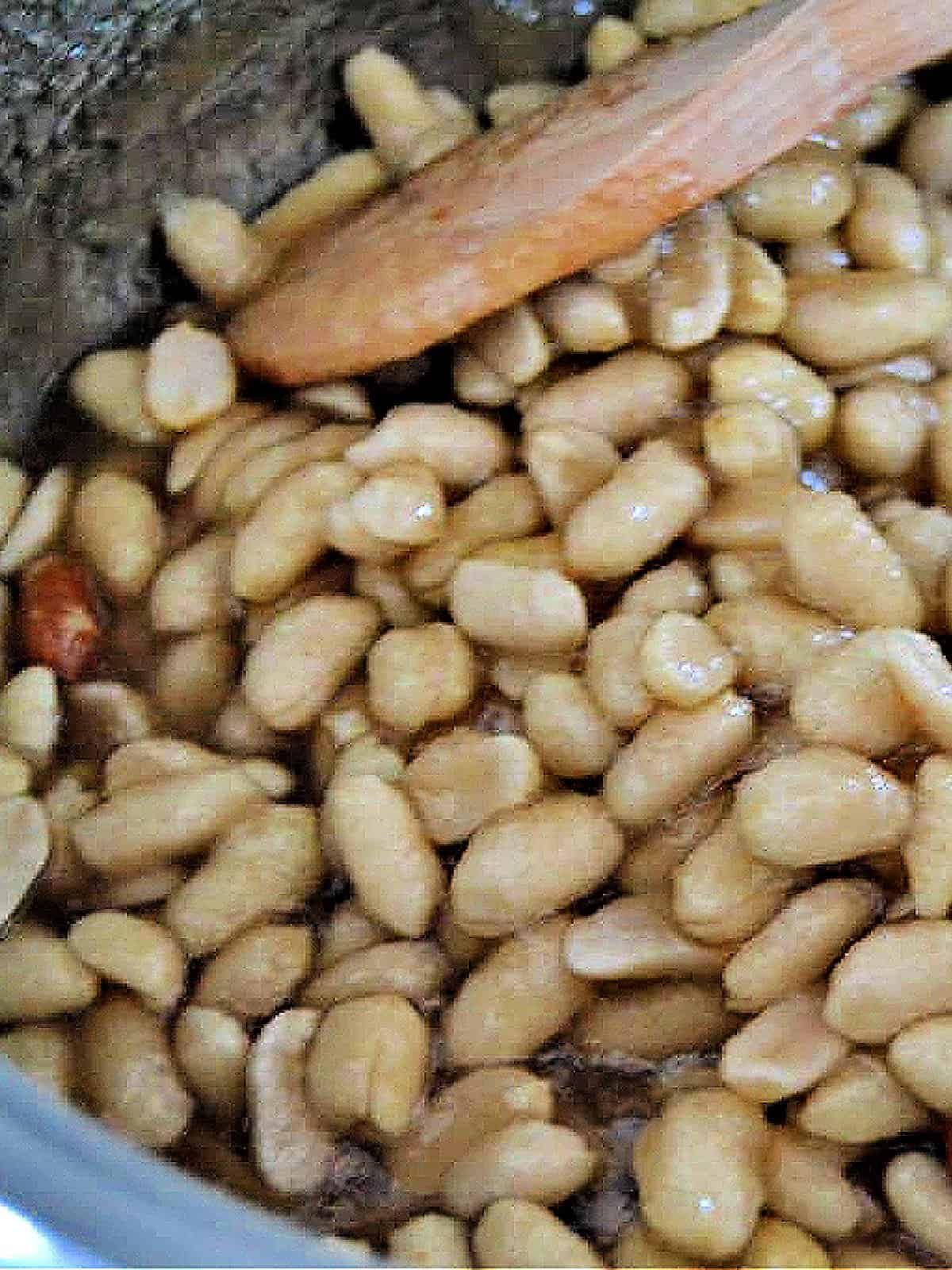 Stirring peanut brittle mixture in a pot.