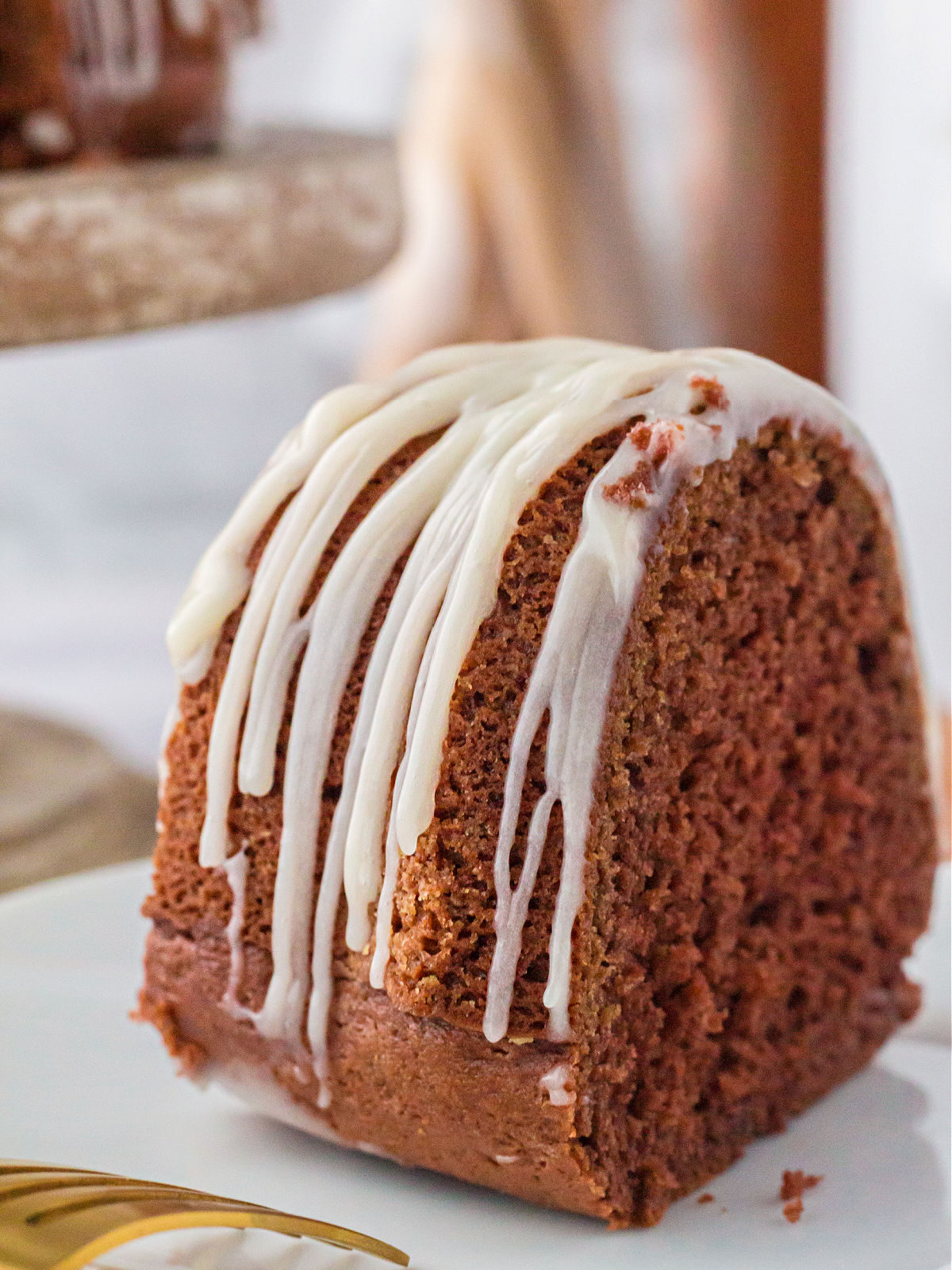 A slice of chocolate cake topped with vanilla icing.